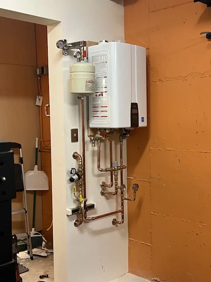 Plumbing technician inspecting water heater connections in Union City